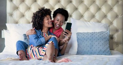 Cheerful Women Relaxing in Modern Bedroom Taking Selfie
