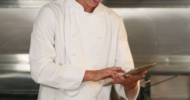 Chef in Uniform Using Digital Tablet in Professional Kitchen - Download Free Stock Images Pikwizard.com