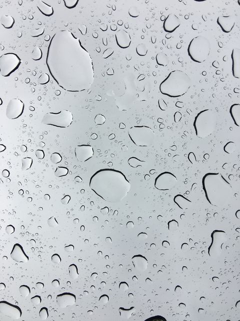 Raindrops on glass with a clear sky backdrop create a tranquil and refreshing effect. Ideal for use in weather-related projects, environmental awareness campaigns, freshness advertisements, or metaphors for calm and clarity.