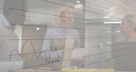 Diverse colleagues discussing work overlaid with business graphs
