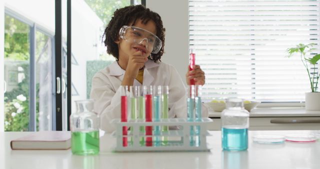 Happy biracial boy making chemistry experiments, holding test tube - Download Free Stock Photos Pikwizard.com