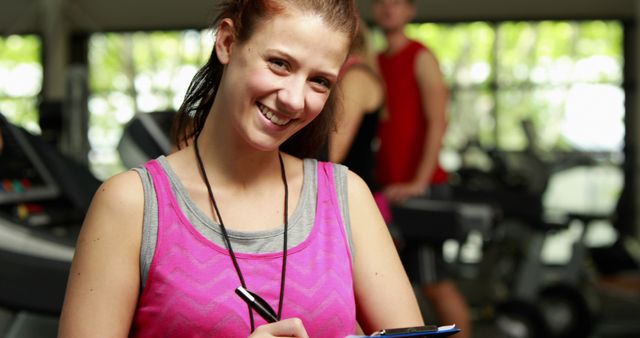 Female Fitness Instructor Taking Notes in Gym - Download Free Stock Images Pikwizard.com