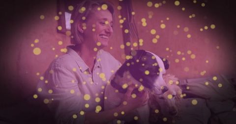 Smiling Woman Embracing Dogs in Warm Lighting