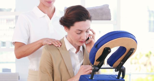 Businesswoman Receiving Chair Massage While Talking on Phone - Download Free Stock Images Pikwizard.com