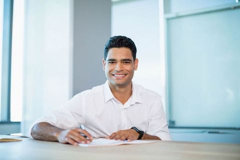 Smiling Professional Man Working at Office Desk