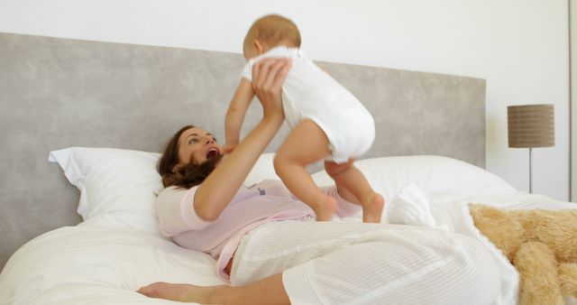 Happy mother playing with baby on bed - Download Free Stock Images Pikwizard.com