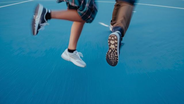 Teens jumping on blue court with sneakers and motion blur capturing energetic movement