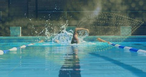 Man engaging in front crawl stroke in sunlit lap pool