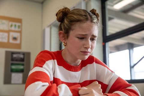 Thoughtful young student in classroom by window