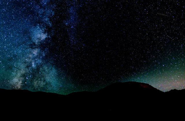 Capturing the majestic view of the Milky Way as it illuminates the dark night sky over a silhouette of mountains. Perfect for science and nature projects, wallpaper backgrounds, educational materials, or emphasizing the beauty of the universe.