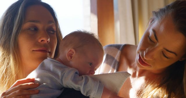 Loving Mothers Holding Newborn Baby in Sunlit Room - Download Free Stock Images Pikwizard.com