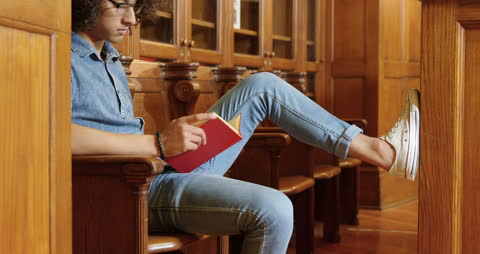 Young Man Reading in Library Relaxed and Focused
