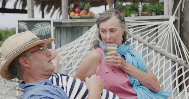 Elderly Couple Relaxing on Hammock Drinking Refreshments Outdoors - Download Free Stock Images Pikwizard.com