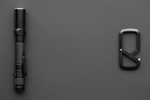 Black Flashlight and Carabiner on Dark Background