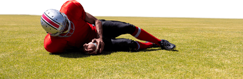 Transparent american football player lying on field in red uniform