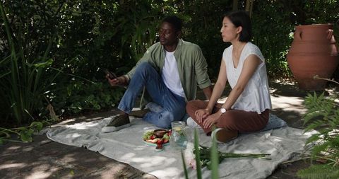 Interracial Couple Enjoying Picnic in Serene Garden Setting