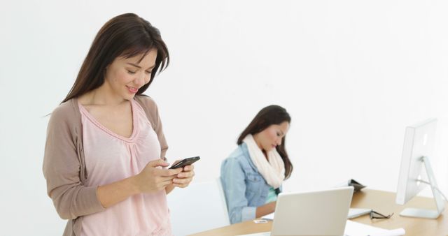 Young Women Working and Using Smartphones in Modern Office - Download Free Stock Images Pikwizard.com