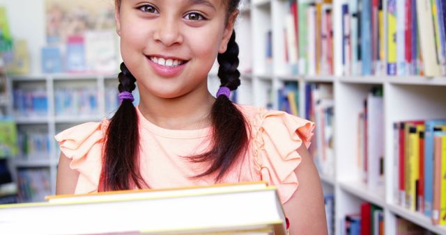 Smiling Schoolgirl Holding Books in Library Setting - Download Free Stock Images Pikwizard.com