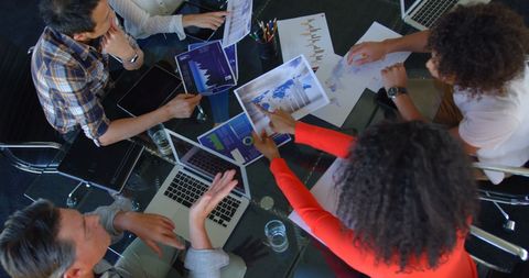 Team Collaborating on Business Graphs in Office Meeting