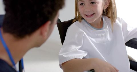 Smiling pediatric patient in wheelchair during medical consultation