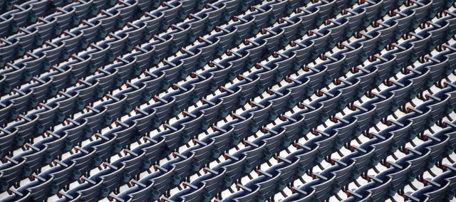 Empty blue stadium seats are organized in perfect rows and columns, creating a symmetrical and repetitive pattern. This image can be used to symbolize order, organization, and public events like sports games or concerts. Ideal for themes related to sports venues, arena preparations, and large gatherings.