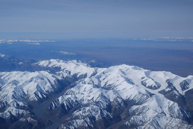 Aerial View of Snow-Capped Mountain Range on Clear Day - Download Free Stock Photos Pikwizard.com