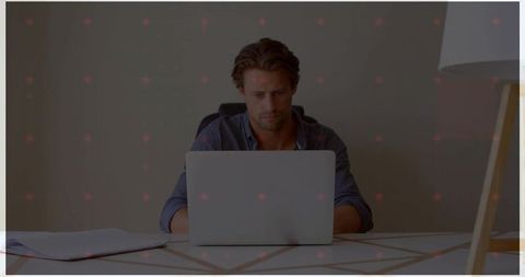 Focused Man Typing on Laptop in Modern Home Office