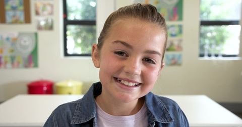 Smiling schoolgirl in classroom setting reflecting joy and learning