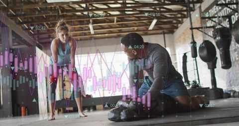 Female athlete training with coach wrapping hands for boxing workout in industrial gym