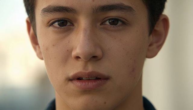 Close-up teen male portrait with natural skin texture and direct gaze