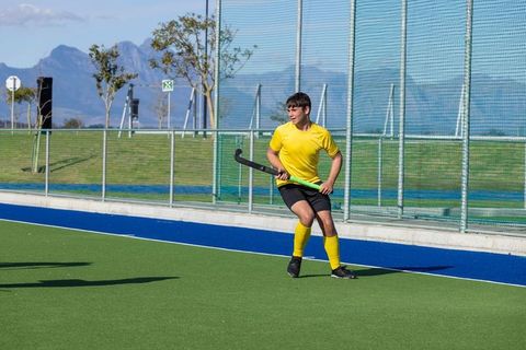 Teenage Hockey Player Dribbling on Turf Field During Match