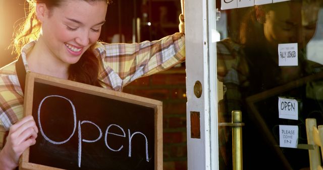 Waitress showing chalkboard with open sign in cafe 4k