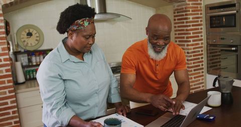 Senior African-American Couple Using Laptop in Cozy Kitchen