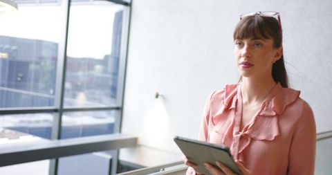 Focused businesswoman utilizing tablet in modern office space