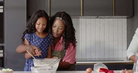 Mother and daughter bonding in modern kitchen baking together