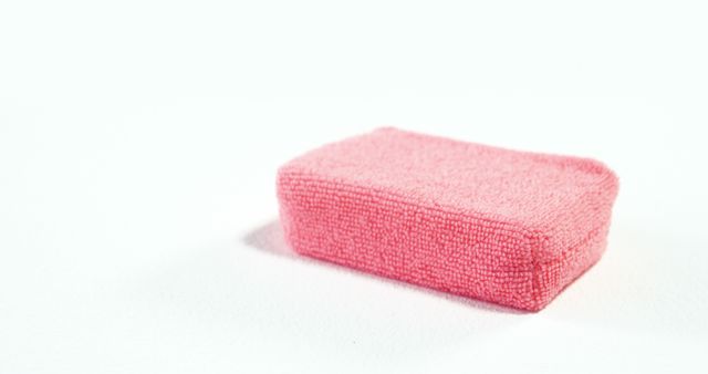 A pink eraser is placed against a white background, with copy space. Erasers like this are commonly used by students and professionals to correct pencil mistakes on paper.
