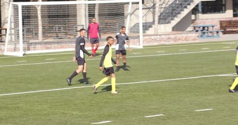 Boys Playing Soccer on School Field, Engaged in Active Sports