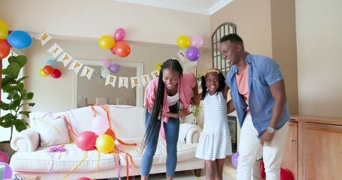 Joyful family celebrating birthday with balloons and smiles