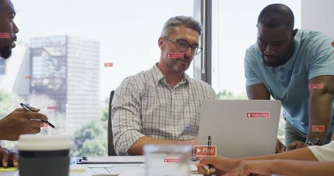 Manager discussing reports on laptop with diverse team and notifications