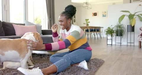 Cheerful Woman Playing with Dog in Cozy Living Room