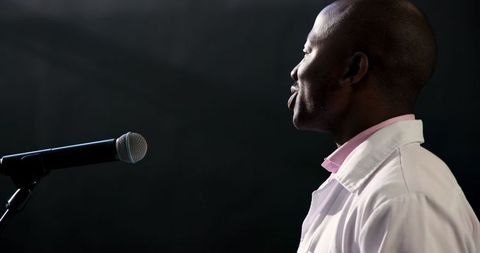 Confident male speaker giving healthcare presentation on stage