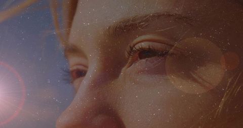 Dreamy close-up female portrait with eye detail, lens flare and starry bokeh overlay