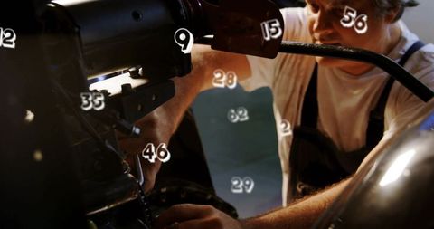 Mechanic tightening bolts on engine with numeric callouts in workshop closeup hands repair