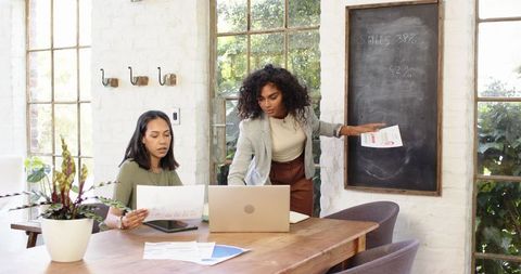 Professional women collaborating in modern loft office space