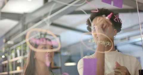 Creative Professionals Collaborating at Office Glassboard