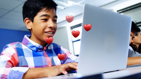 Smiling Boy Engaging with Heart Icons on Laptop Display