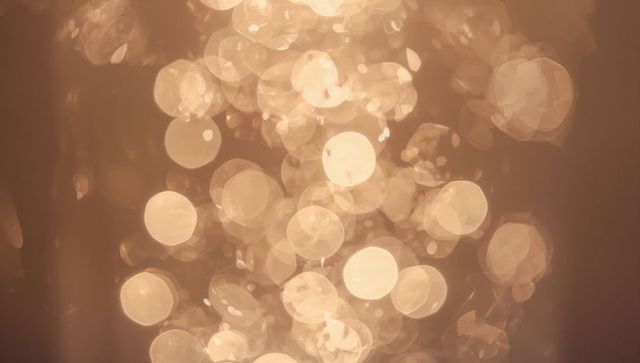 Glowing Golden Bokeh Orbs Creating Soft Abstract Light Background for Holiday and Branding