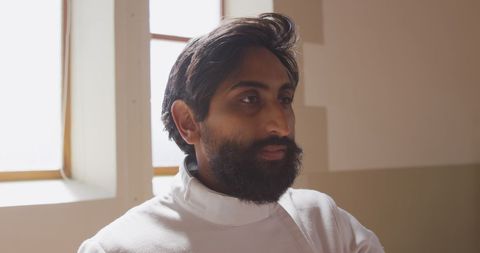 Focused Fencer Preparing in Sunlit Room