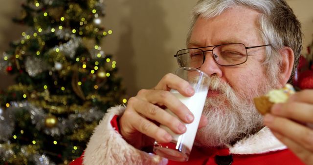 Santa Claus Enjoying Milk and Cookies by Christmas Tree - Download Free Stock Images Pikwizard.com