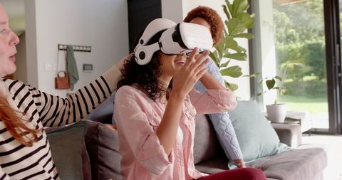 Friends Enjoying Virtual Reality at Modern Home by Large Glass Doors